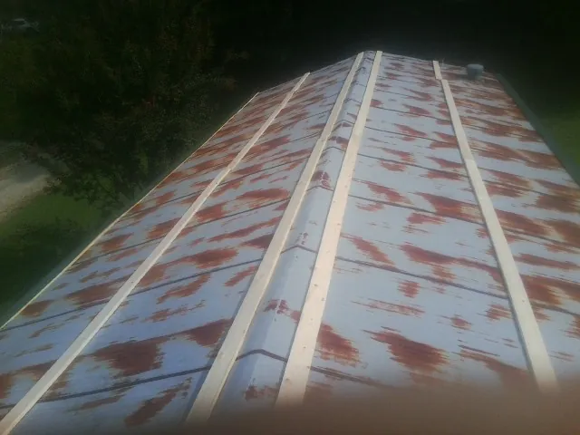 Rusted metal roof panels with new wood purlins before replacement — Storm Damage Roof Repair in Oklahoma City by Roofing Brothers