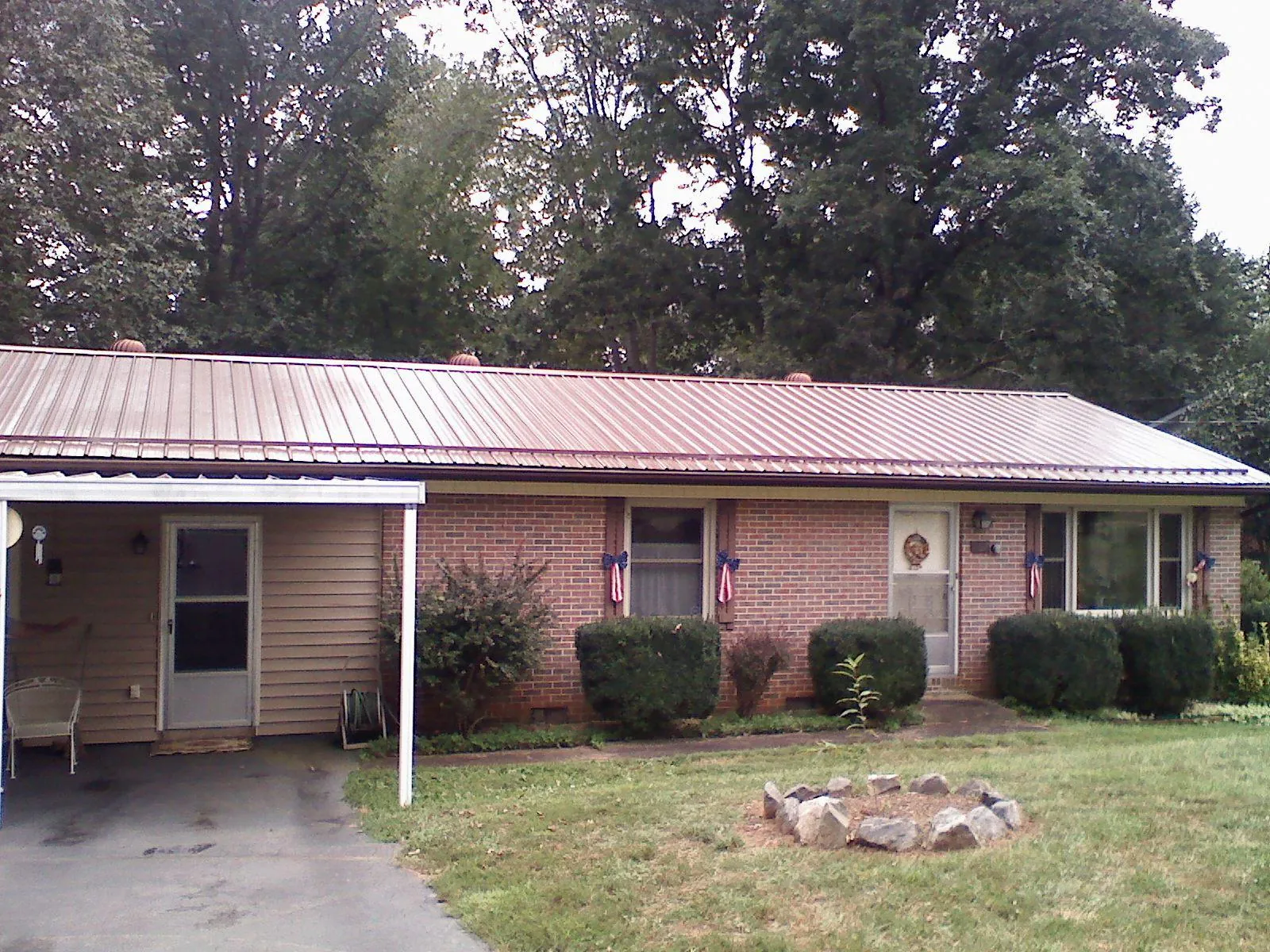 Bronze metal roof and carport on a brick ranch home — Roof Repair work by our crew in Oklahoma City