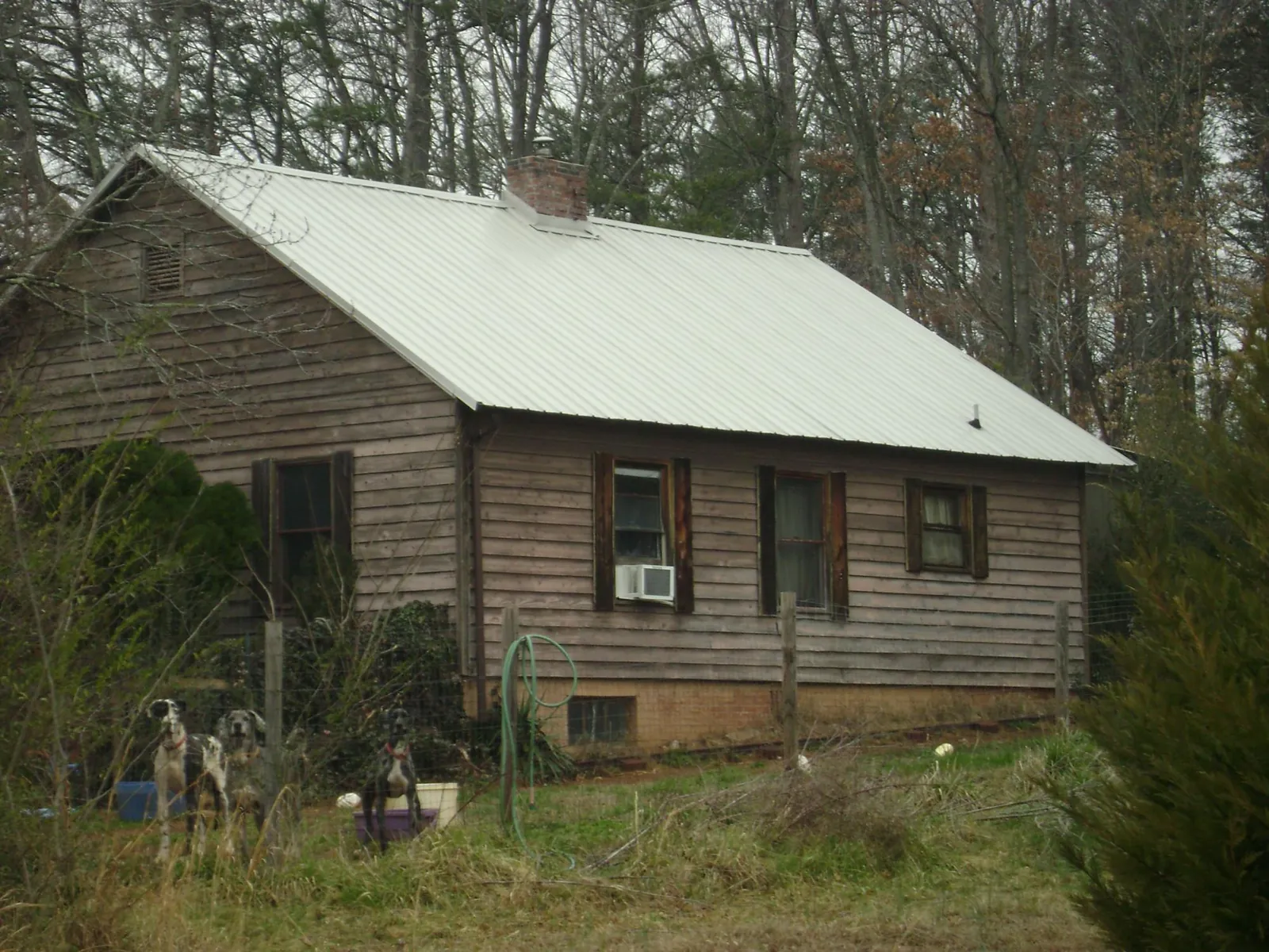 White metal roof on an old wood sided farmhouse, from a Asphalt Shingle Roof Repair job in Oklahoma City